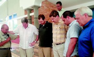 A Guatemalan pastor, far left, prays for Tennessee Baptist volunteers, from left, Dale Ellenburg, Pigeon Forge; Channing Kilgore, Whitwell; Troy Luttrell, Kimball; Brent Moore, Clarksville; and Sing Oldham, Hendersonville. Looking on is the president of the Guatemala Baptist Convention.