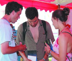 Brady Wood, left, pastor of Pleasant Grove Baptist Church, Hixson, prays with a young man and woman in The Jesus Tent at Bonnaroo. — Photo by Connie Davis Bushey